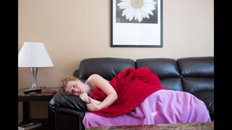 Cheryl Mauthe lies on her couch in pain one day after her lumpectomy in March 2014. The operation involved removing three lymph nodes in her left breast and armpit, causing her more discomfort than she was expecting.