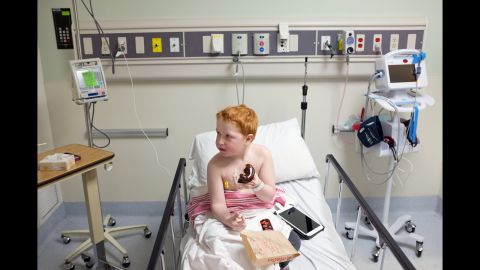 Mauthe's son, Colin, eats a doughnut in the emergency room in March 2014. He was diagnosed with leukemia in 2012, two years before his mother was diagnosed with breast cancer.