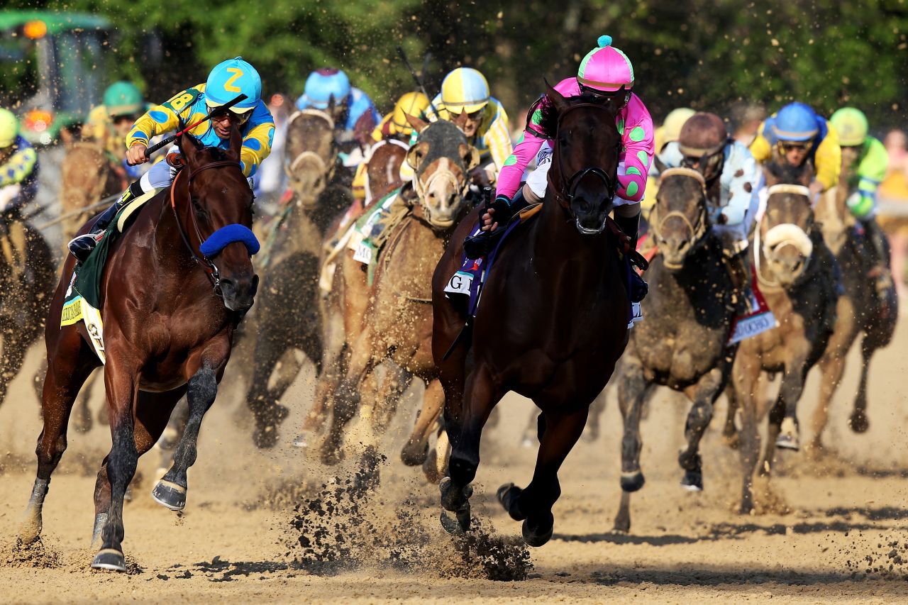 American Pharoah (left) enters the home stretch for the 2015 Kentucky Derby behind Firing Line before powering to victory to win the $1.2 million prize.