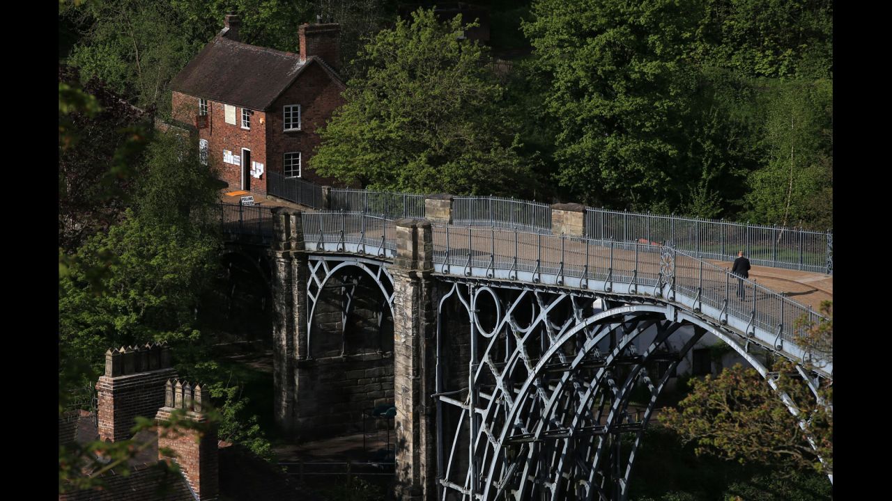A man walks across the world's first-ever iron arched bridge toward a polling station in Ironbridge, England.
