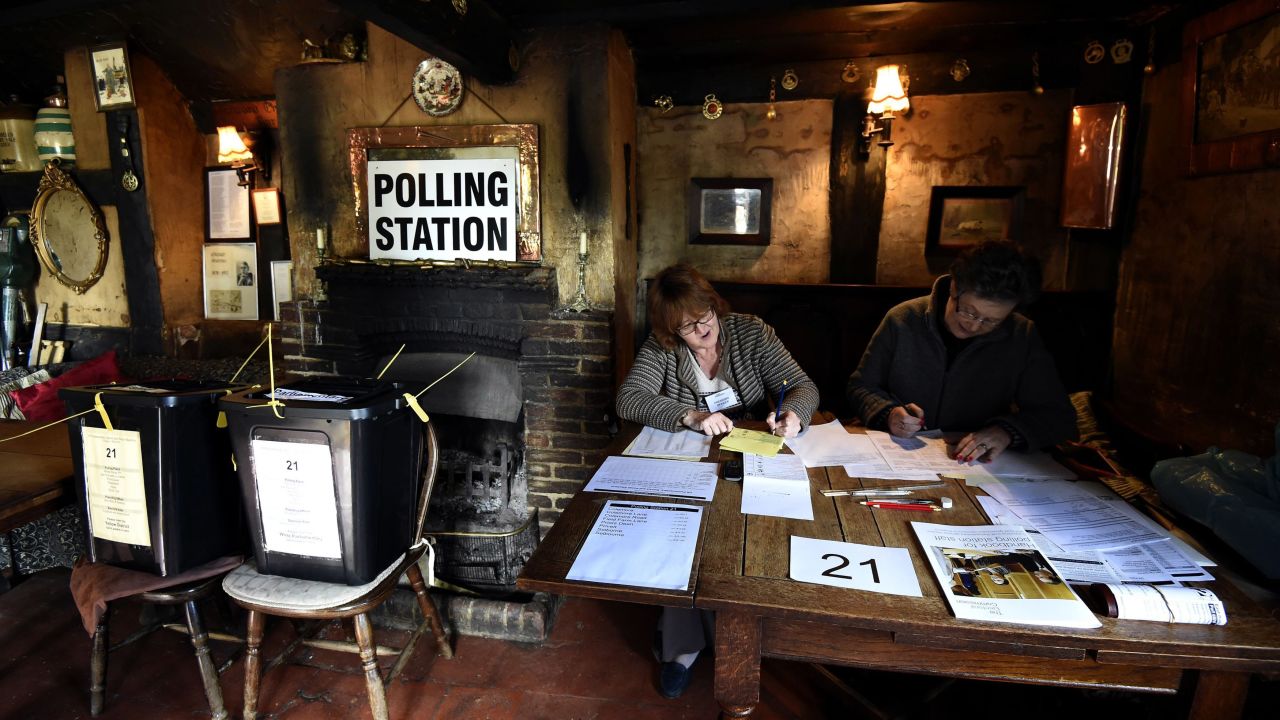 Election officials work at a polling station in the White Horse Inn in Priors Dean, England.