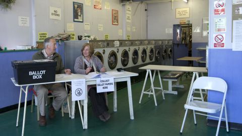 Election officials operate a polling station inside a laundromat in Oxford, England.