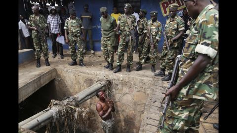 Jean Claude Niyonzima, a suspected member of the ruling party's Imbonerakure youth militia, pleads with soldiers to protect him from a mob after he came out of hiding in a sewer in the Cibitoke district of Bujumbura, Burundi, on Thursday, May 7. Niyonzima fled from his house into the sewer under a hail of stones thrown by a mob protesting President Pierre Nkurunziza's decision to seek a third term in office.