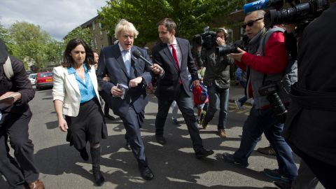 Members of the media follow London Mayor Boris Johnson and his wife, Marina Wheeler, after they voted in London.