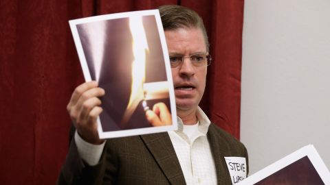 Steve Lipsky of Parker County, Texas, near Dallas, holds photographs of his well water burning during a briefing organized by anti-fracking groups in Washington in February 2014.