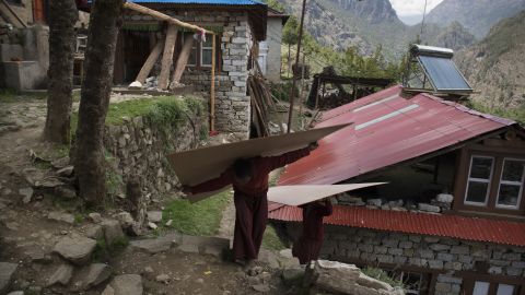 Young monks take wood up to a 500-year-old monastery that was heavily damaged in the earthquake. They are afraid that what remains might still come tumbling down.