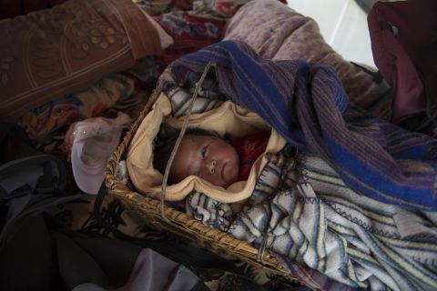 Nawang Sherpa held onto his baby girl during the earthquake. They survived but are now too frightened to sleep within cracked walls. The family of four lives in a tent set up nearby.