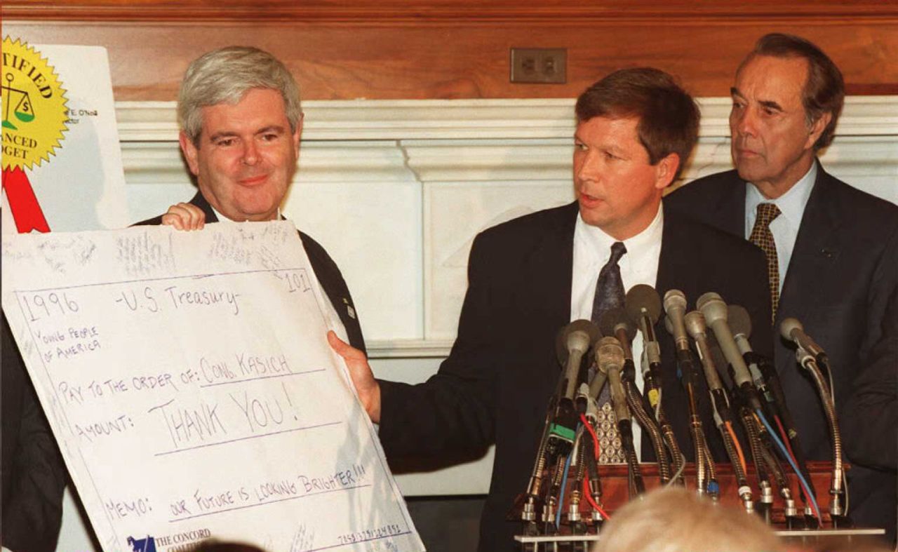 Kasich, center, shows a thank you note in the form of a check to Speaker of the House Newt Gingrich, left, and Senate Majority Leader Robert Dole (right) on November 17, 1995, in Washington. They were soon engaged in bruising battles with President Bill Clinton over the federal budget. 