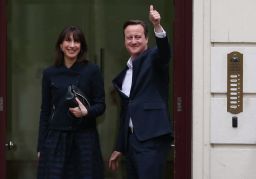 Prime Minister David Cameron arrives in London with his wife Samantha