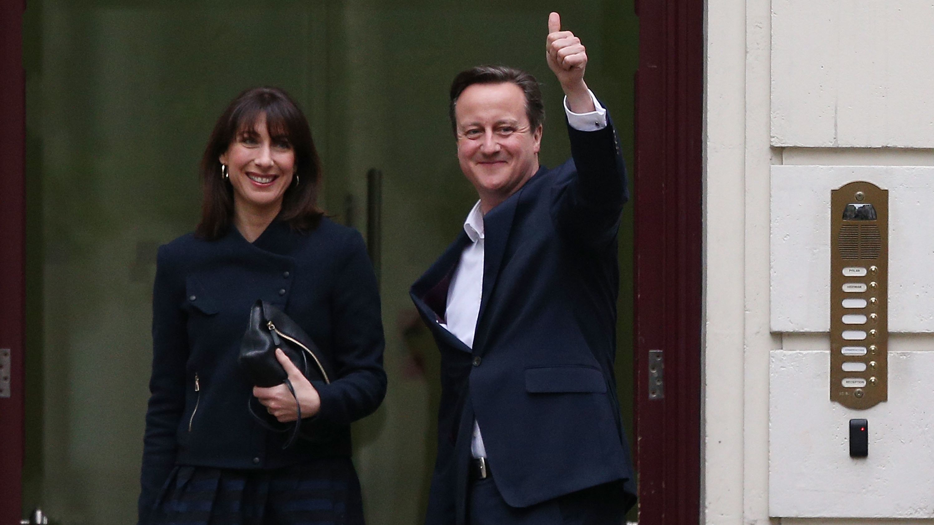 Prime Minister David Cameron arrives in London with his wife Samantha