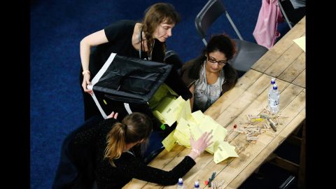 A volunteer empties a ballot box onto a table for votes to be counted in Sheffield, England, on May 8.