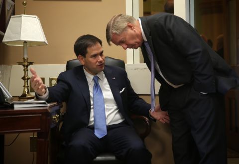Graham talks to U.S. Sen. Marco Rubio, R-Florida, before a news conference on Capitol Hill on July 24, 2014.