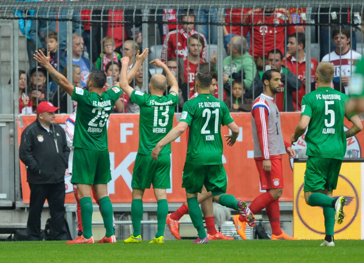 Augsburg players celebrate Raul Bobadilla's winning goal in front of their traveling fans. Their win keeps them on track to book a place in next season's Europa League.