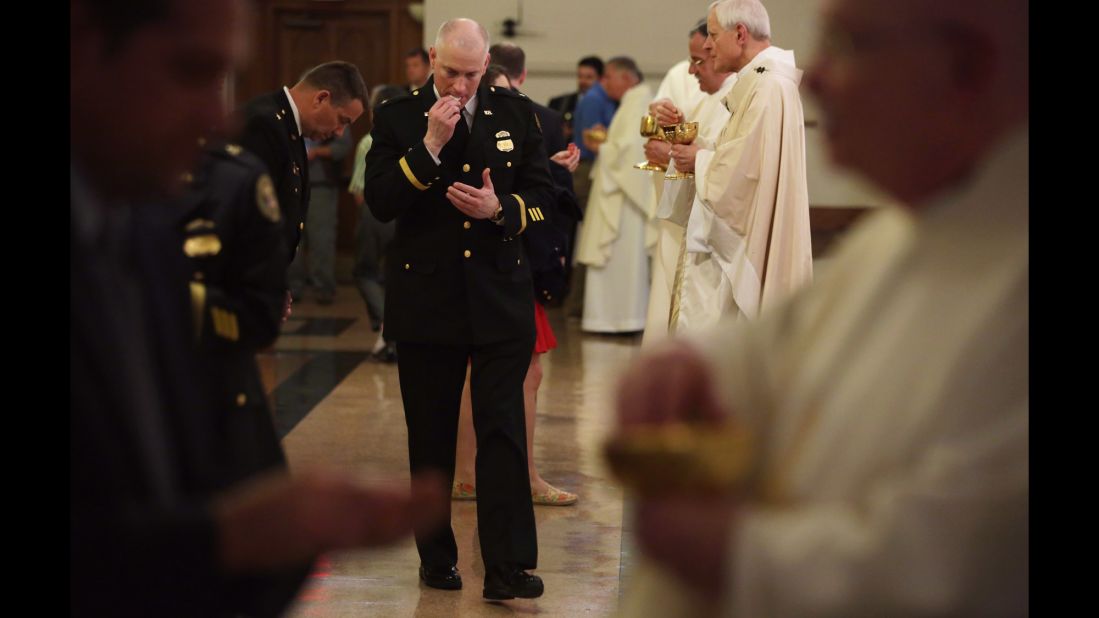Police officers take communion during the Mass on May 5.