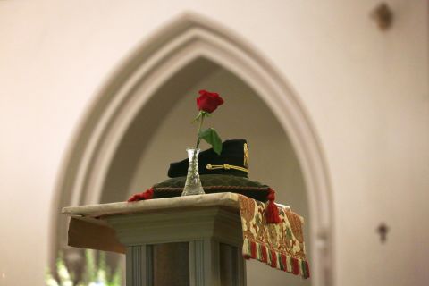 A police hat is placed on a column during the Mass.