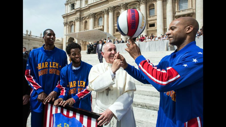 Pope Francis gets a basketball-spinning lesson from Flight Time Lang, a member of the Harlem Globetrotters, during a meeting at the Vatican on Wednesday, May 6.