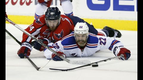Washington defenseman Brooks Orpik, left, and New York Rangers defenseman Dan Boyle reach for the puck while laying on the ice during Game 6 of their NHL playoff series on Sunday, May 10. The Rangers won 4-3 to force a deciding Game 7.