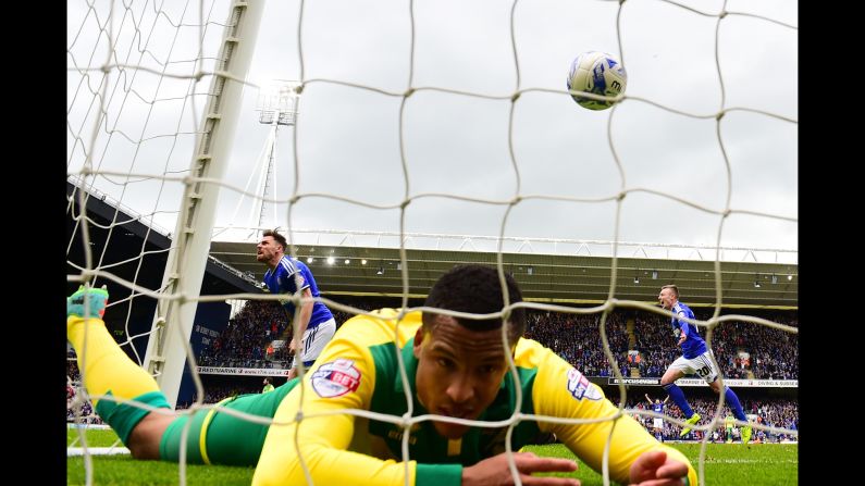 Norwich City's Martin Olsson lies inside his own goal after Ipswich Town's Paul Anderson, left, scored a goal during the first leg of their playoff Saturday, May 9, in Ipswich, England. The rival teams tied 1-1, and they will play once more for the chance to advance to the Championship playoff final. The Championship is the second tier of English soccer. Its playoff winner will be promoted to the Premier League.
