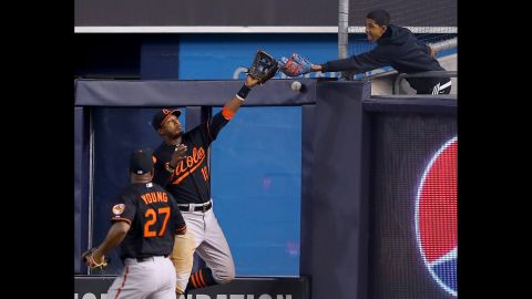 Baltimore's Adam Jones and a fan in Yankee Stadium both try to catch a ball hit by New York's Alex Rodriguez on Friday, May 8. Neither made the catch, and Rodriguez reached third base on the play.