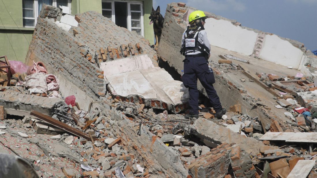 A rescue worker from the U.S. Agency for International Development looks for survivors in Kathmandu along with a sniffer dog on May 12.