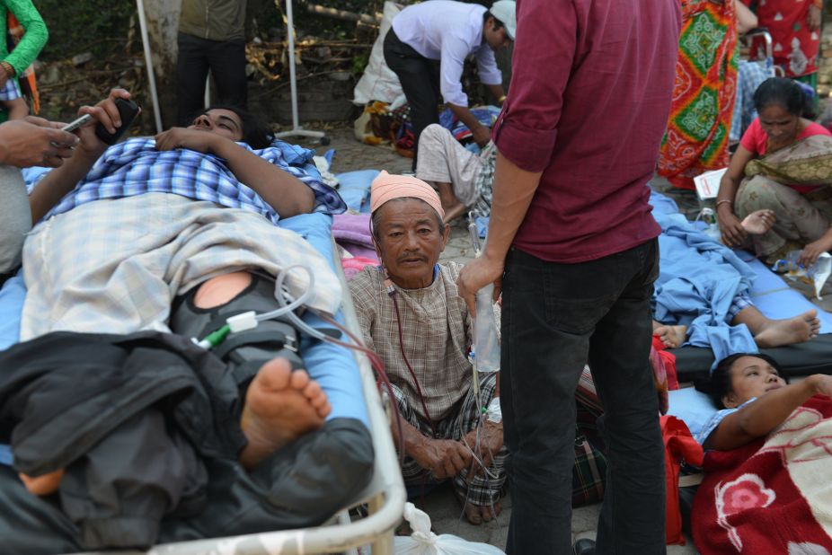 Patients lie on stretchers in an open area after being carried out of a hospital building on May 12.