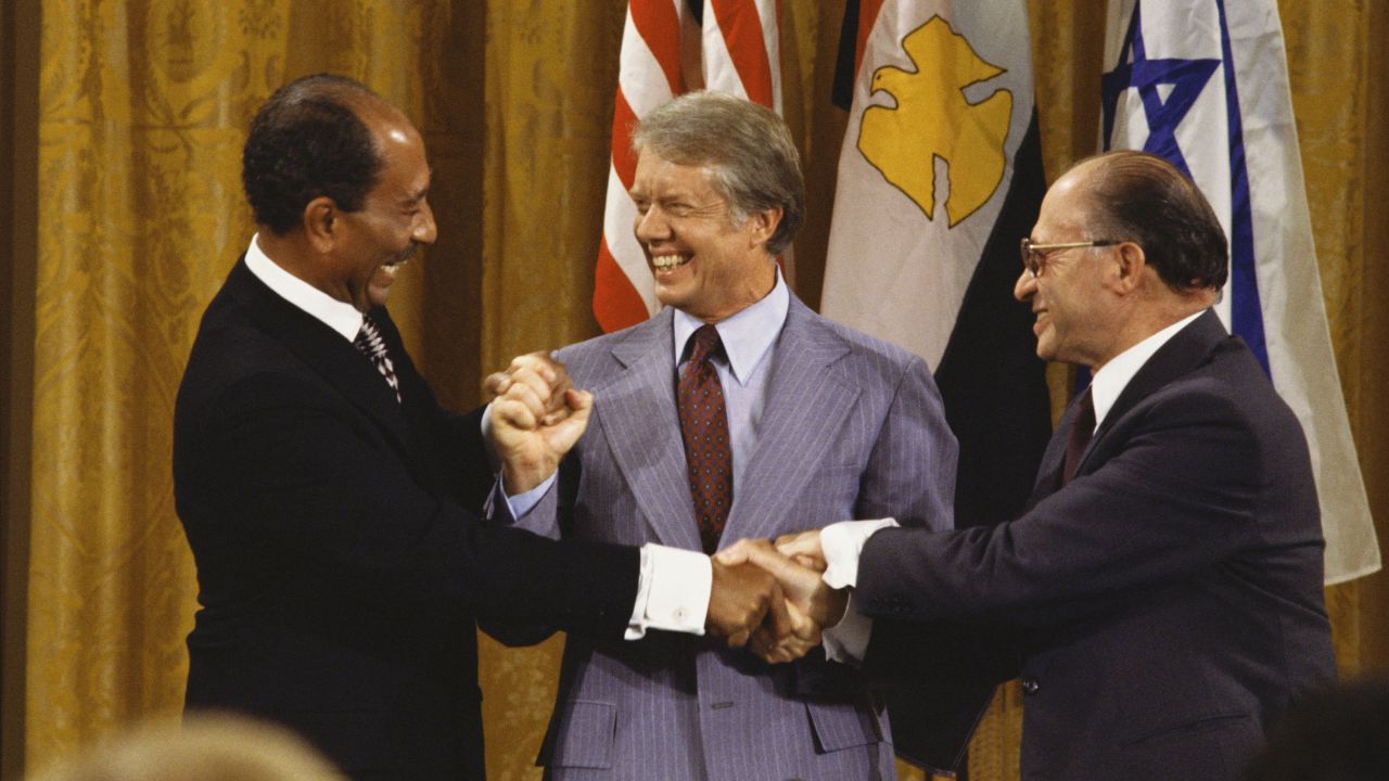 Egyptian President Anwar Sadat, left, joins hands with Israeli Prime Minister Menachem Begin, right, on September 18, 1978, after the Camp David Accords were signed in Maryland. After 12 days of secret meetings, the two sides agreed upon a step toward peace. U.S. President Jimmy Carter, center, personally led the lengthy negotiations and discussions between the two parties.