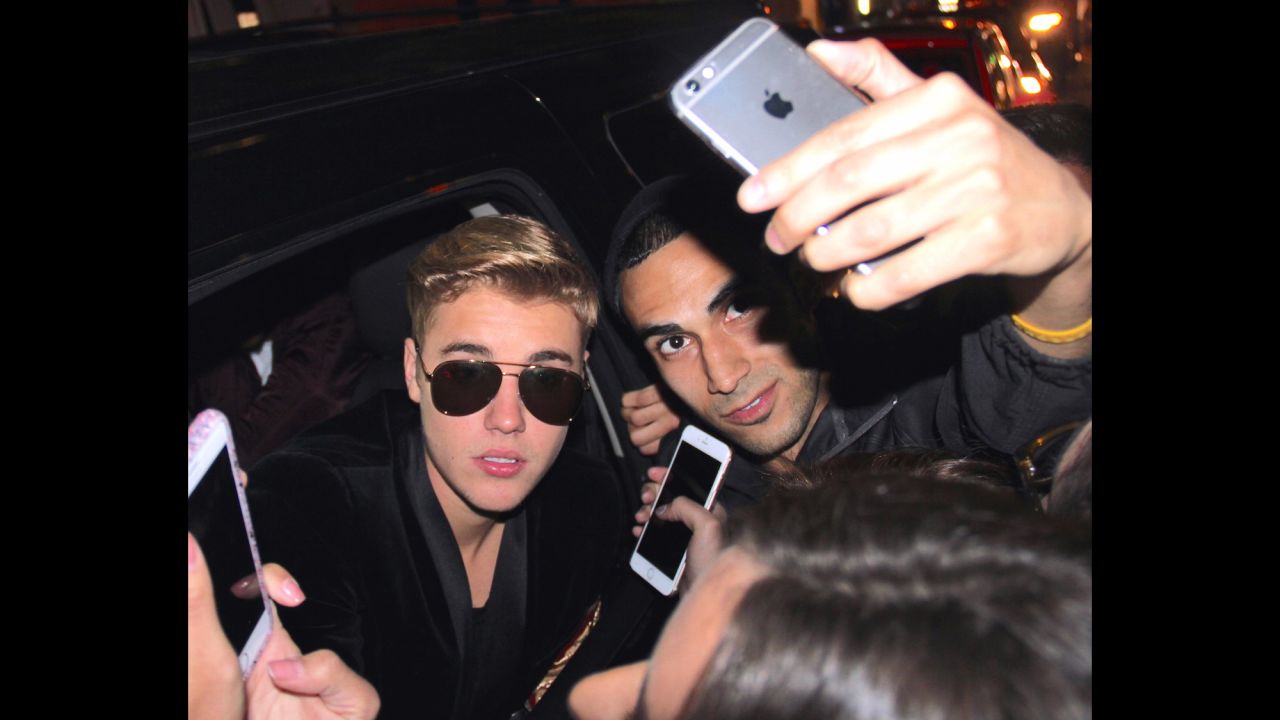 Pop star Justin Bieber sticks his head out a car window to pose for fan photos in New York on Thursday, May 7.
