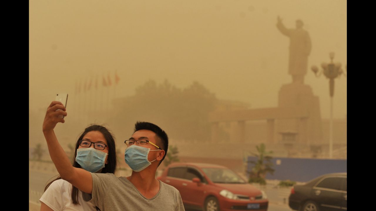 A couple takes a selfie near a statue of Mao Zedong during a sandstorm in Kashgar, China, on Sunday, May 10. <a href="http://www.cnn.com/2015/05/06/living/gallery/selfies-look-at-me-0506/index.html" target="_blank">See 21 selfies from last week</a>