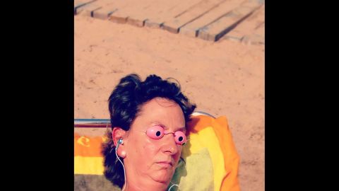 A woman uses protective eyewear while tanning.