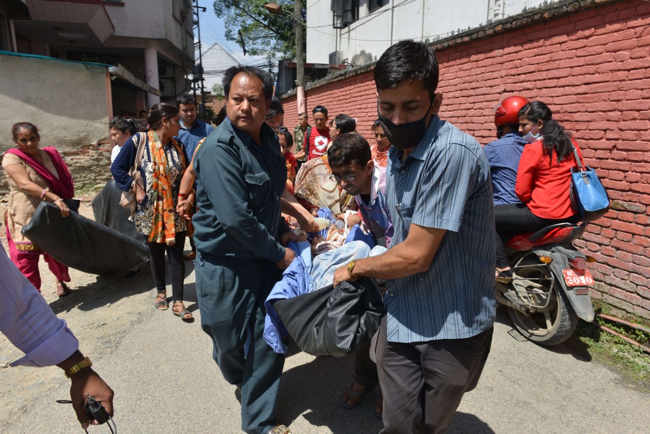 People are carried out of a hospital building in Kathmandu on May 12.
