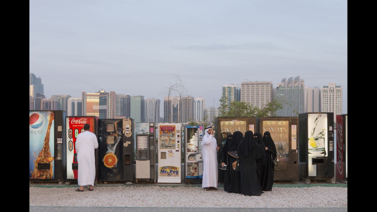 People stand in front of vending machines in Abu Dhabi, United Arab Emirates. Philip Cheung's photo series "Desert Dreams" shows the contrast between modern and traditional life inside the country.