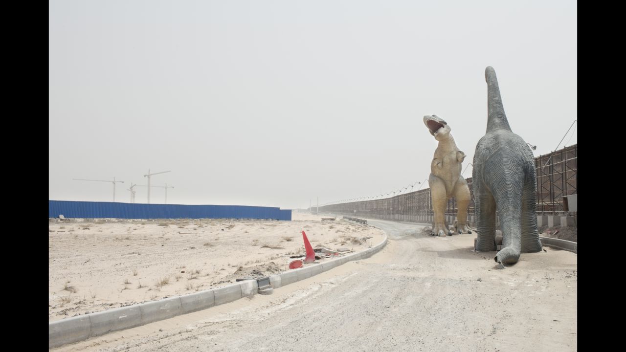 Dinosaur replicas hover over an inactive construction site at the Falcon City of Wonders, on the outskirts of Dubai.