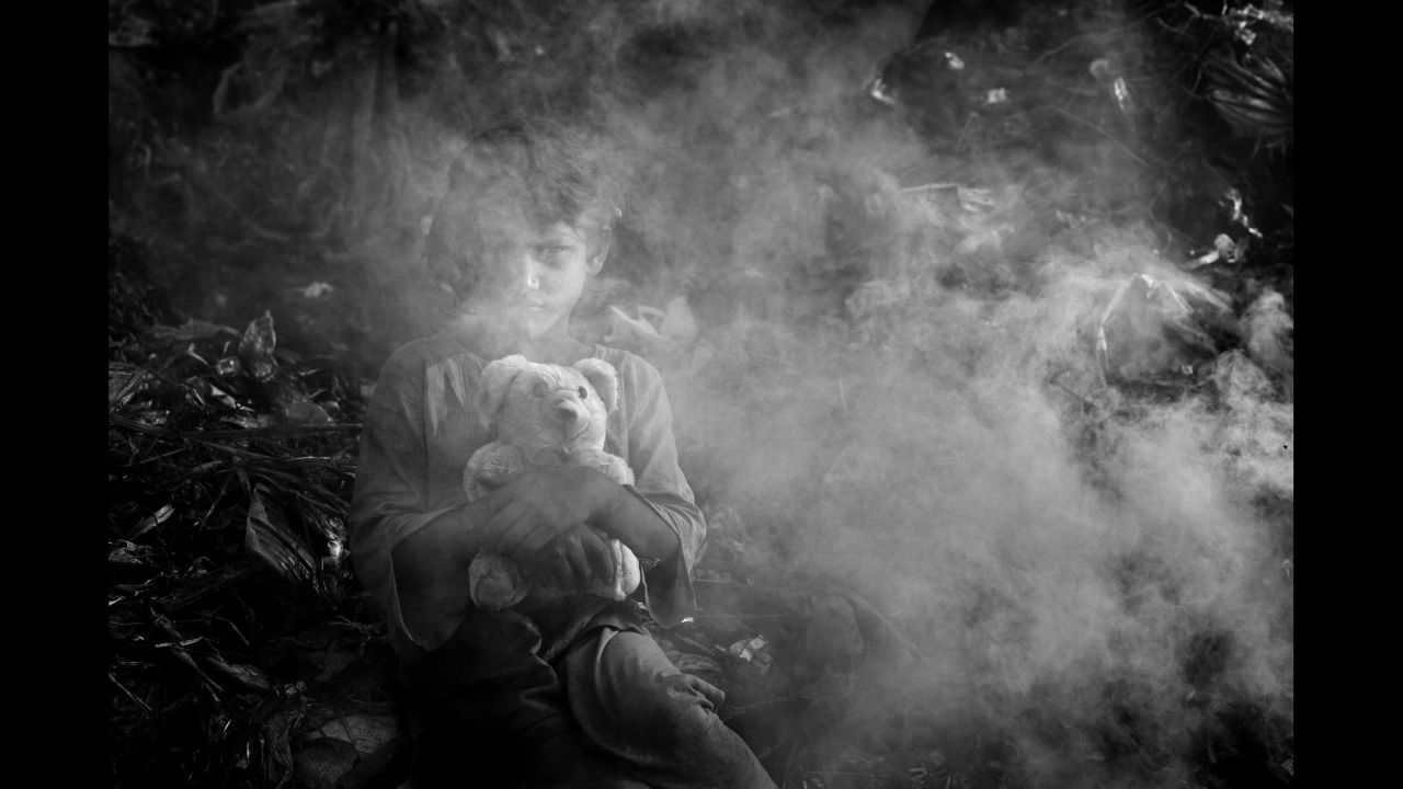 Popy, 8, clutches her stuffed bear while working at a dump in Chittagong, Bangladesh. She is one of the many child laborers profiled by photographer Md Shahnewaz Khan.