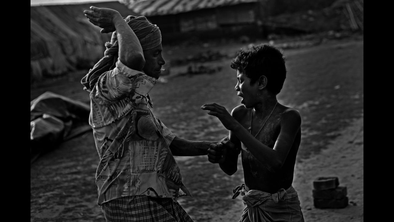 Shafik, 11, is beaten by his master, Khan said, at a brickyard in Chittagong. The child was accused of playing when he was supposed to be working.