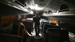 A crime scene investigator looks inside a train car.