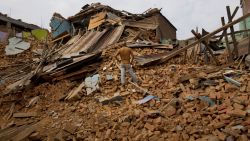 A man stands on debris in Chautara, Nepal, on Wednesday, May 13.