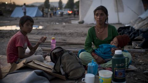 A woman holds a child as she sits out in the open in Kathmandu following a second major earthquake on May 12.