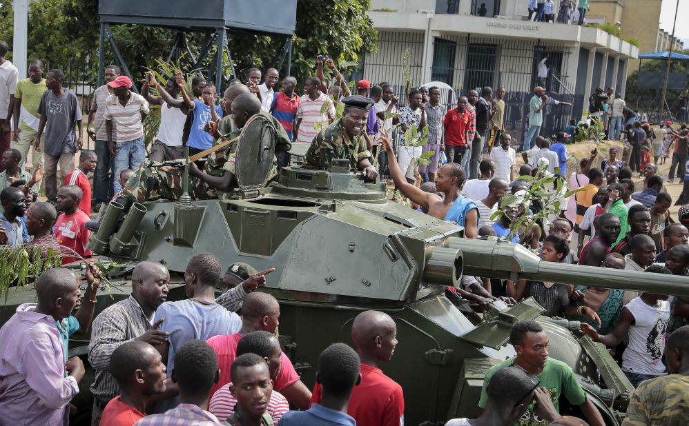 With army soldiers riding in an armored vehicle, demonstrators in Bujumbura celebrate the reported coup attempt on May 13.
