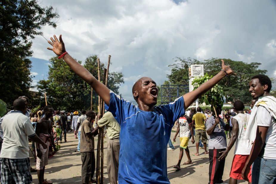 A man raises his arms as people celebrate in the streets of Bujumbura on May 13 after a radio announcement that Nkurunziza was overthrown.
