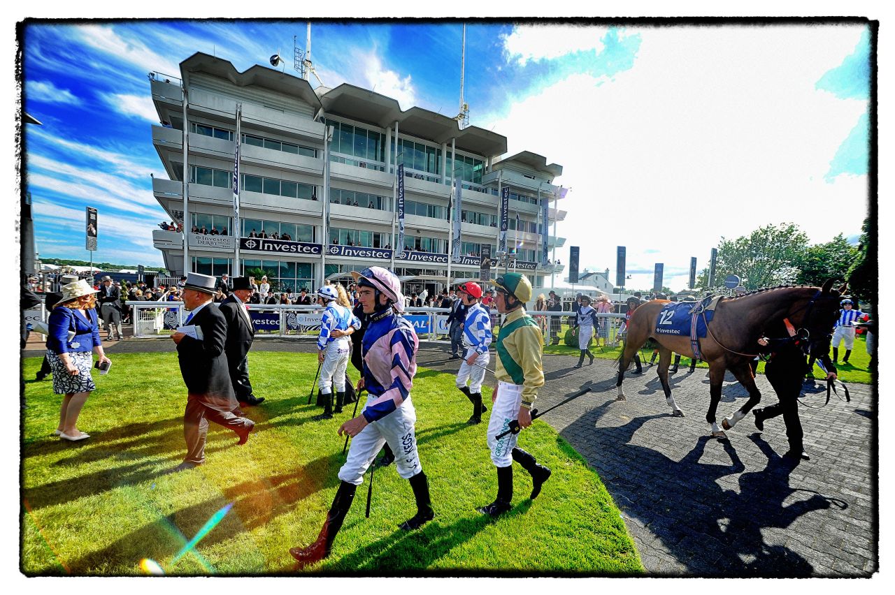 Ahead of each race, jockeys make their way into the parade ring to meet the owners and saddle up on their mounts.