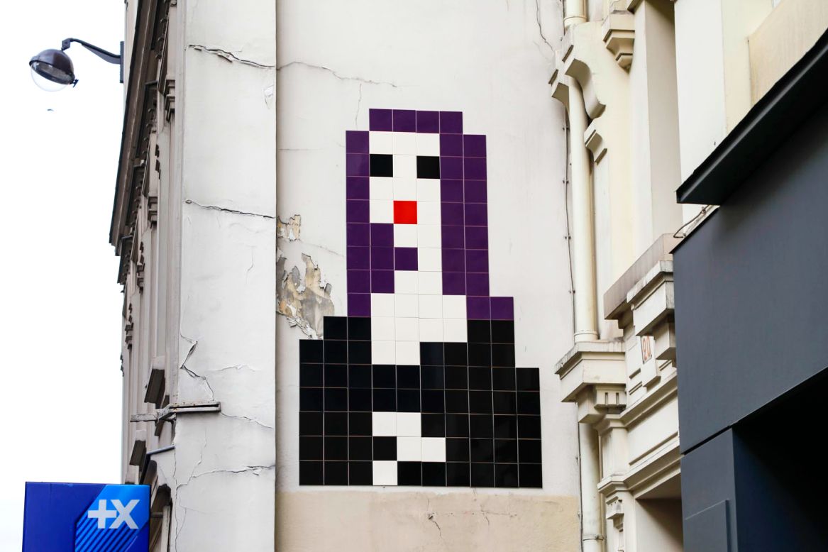 Invader's version of Mona Lisa... on a wall above the streets of Paris.