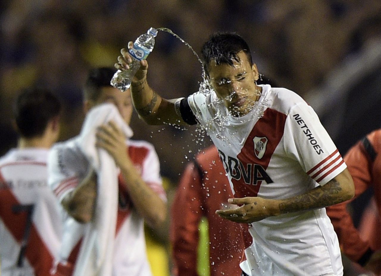River defender Leonel Vangioni pours water on his face after being sprayed as he came out for the second half. He was one of four players reportedly taken to hospital for treatment.