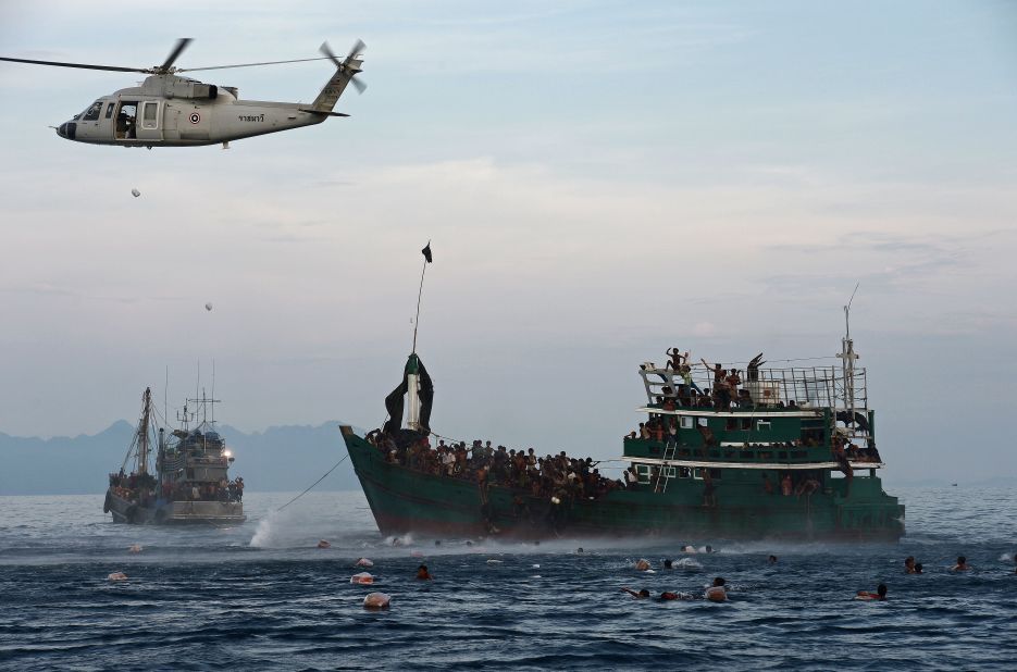 Rohingya migrants swim to collect food supplies dropped by a Thai army helicopter after they jumped from the boar adrift in Thai waters on May 14.  With the Thai pipeline for illegal migrants closed, overcrowded traffickers' boats have begun offloading their human cargo on the shores of Malaysia and Indonesia -- Muslim-majority countries that have shown sympathy to the Rohingya in the past. Alternatively, crews have simply abandoned them to drift.