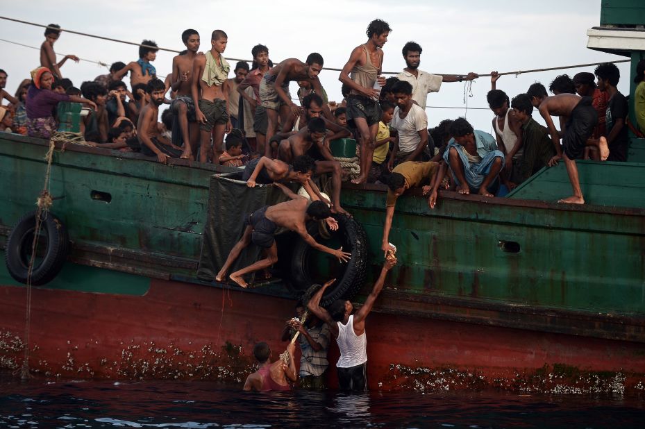 Rohingya migrants pass food supplies dropped by a Thai army helicopter to others aboard the boat. The Indonesian spokesman said Indonesia was currently providing food and shelter to 582 migrants rescued on May 10 and was working with international bodies to provide them documentation and temporary relocation.  