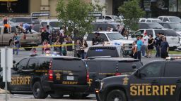 People at the Central Texas MarketPlace watch a crime scene near the parking lot of a Twin Peaks restaurant on Sunday, May 17 in Waco, Texas.