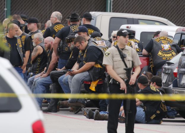 A McLennan County deputy stands guard near a group of bikers.