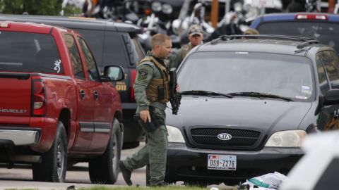 A law enforcement officer walks through the parking lot near the scene of the shooting.