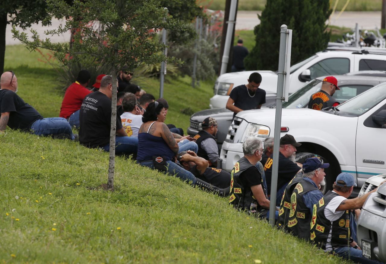 Bikers wait on a hill near the parking lot of the restaurant.