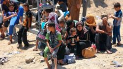 Displaced Iraqis from Ramadi rest before crossing the Bzebiz bridge after spending the night walking towards Baghdad, as they flee their hometown, 65 km west of Baghdad, Iraq, Saturday, May 16, 2015. Islamic State militants seized the center of Ramadi in western Iraq and raised their black flag over the government compound, local officials said.