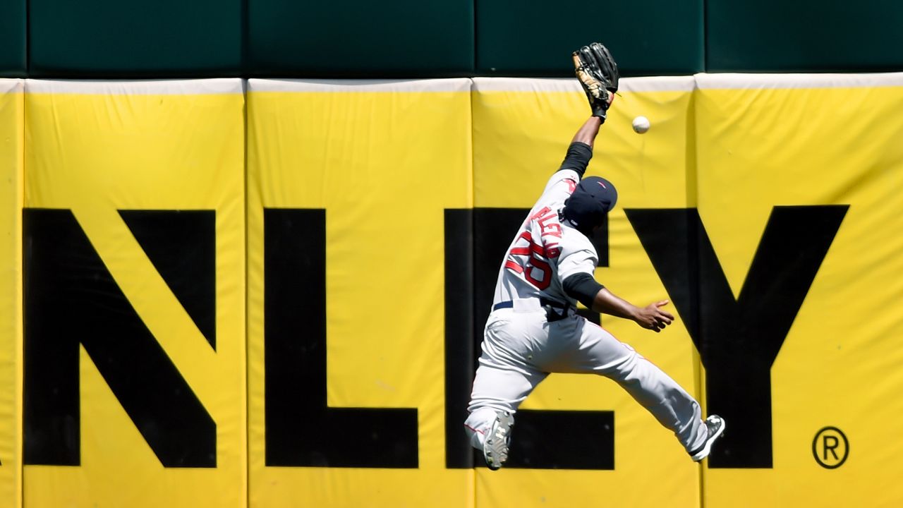 Boston's Jackie Bradley Jr. leaps near the outfield wall but can't make the catch during a game in Oakland, California, on Wednesday, May 13.